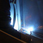 Fabricator welding a steel container