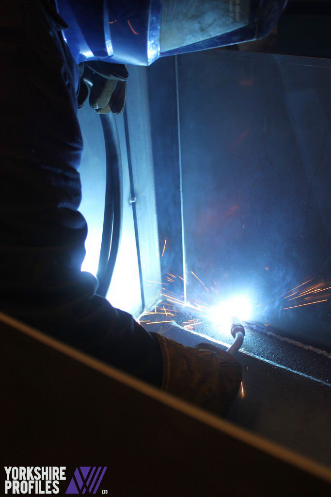 Fabricator welding a steel container